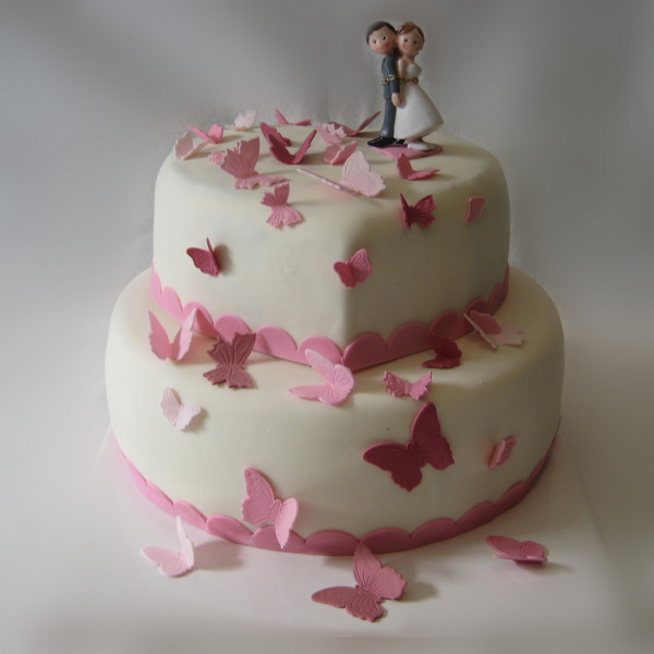 Hochzeitstorte mit Schmetterlingen und verliebter Brautpaarfigur