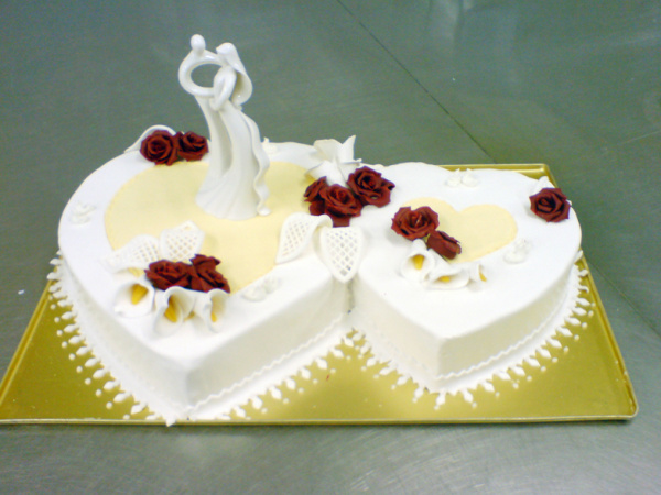 Weiße Herz-Torte mit Hochzeitstortenfiguren