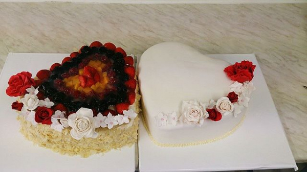 Hochzeitstorte als Herz mit Früchten und Blumendekoration