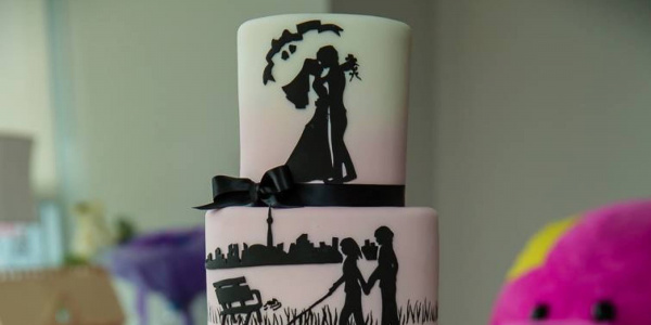 Weiße Hochzeitstorte mit schwarzen Figuren